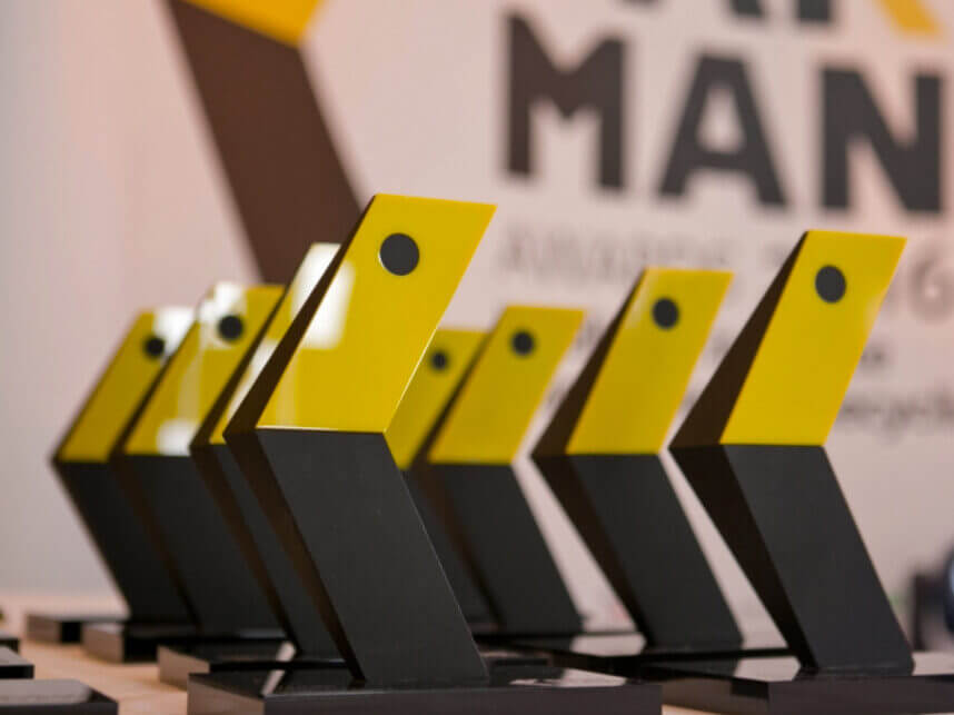 A group of Pakman awards in black and yellow. on a table. in the shape of a 3D P